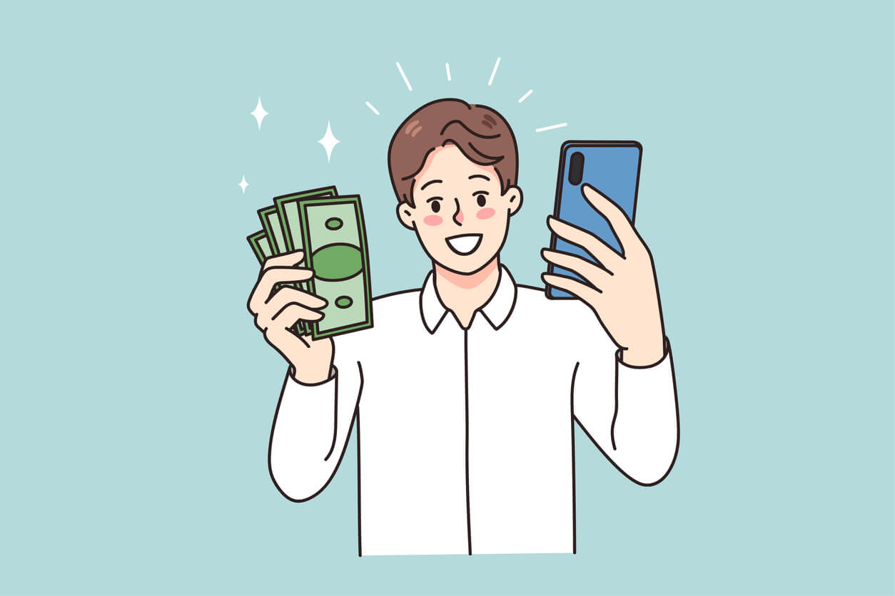 man holding cash in one hand and his phone in the other