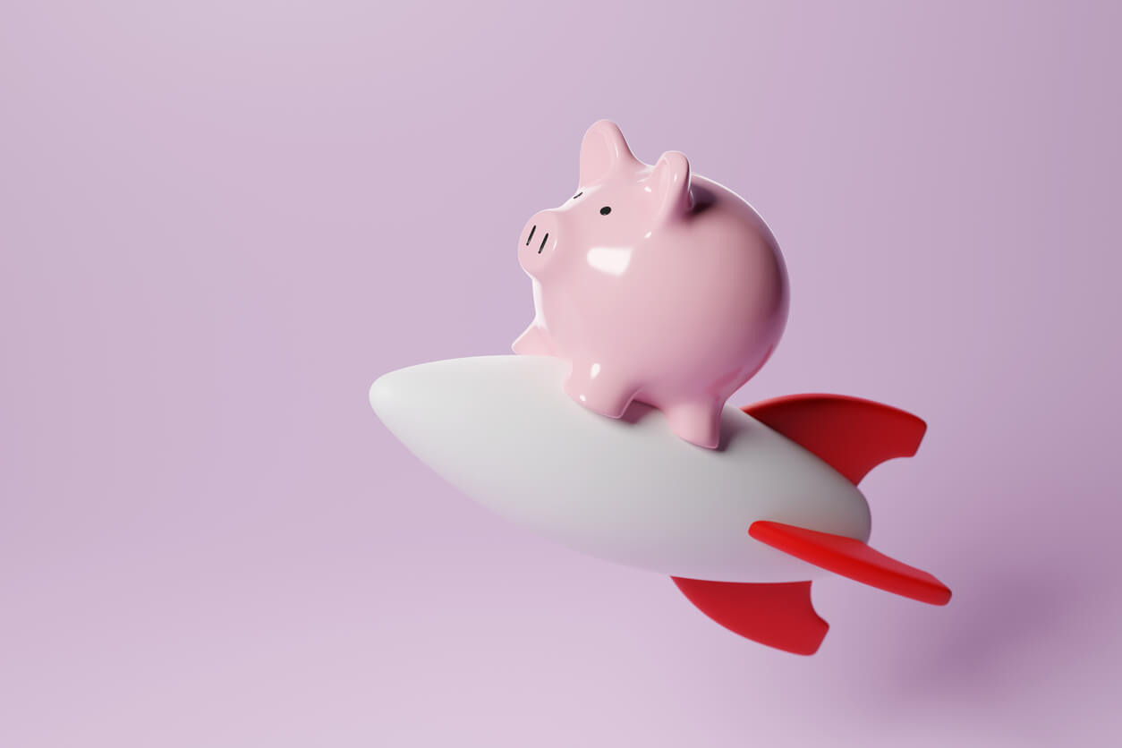 piggy bank riding on a rocket ship